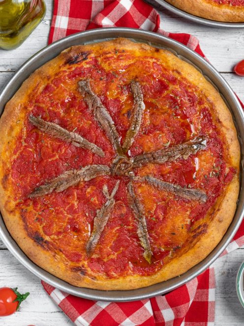 Focaccia integrale alla marinara con salsa di pomodoro e acciughe disposte a raggiera