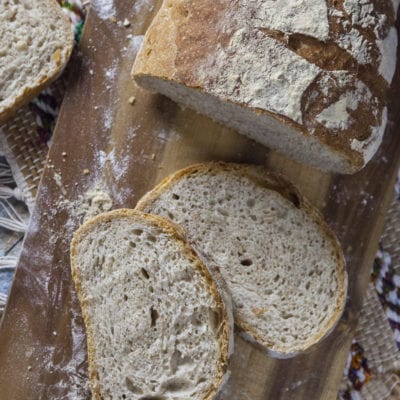 Pane con farina integrale affettato, con crosta rustica infarinata e mollica alveolata ben visibile