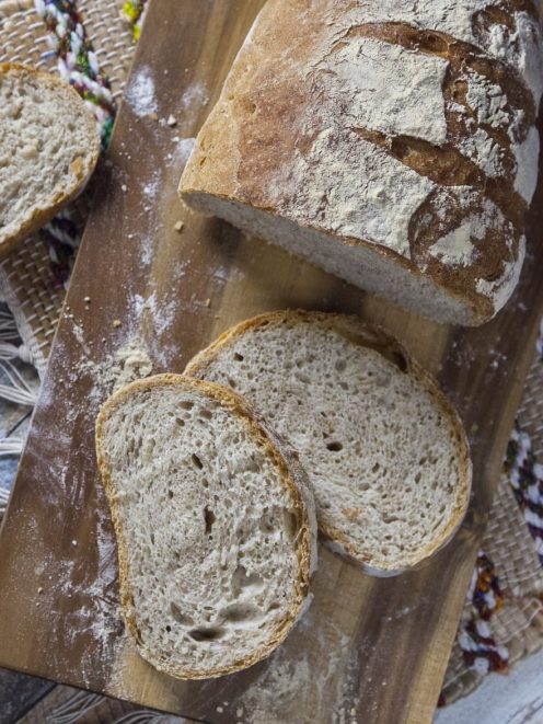 Pane con farina integrale affettato, con crosta rustica infarinata e mollica alveolata ben visibile
