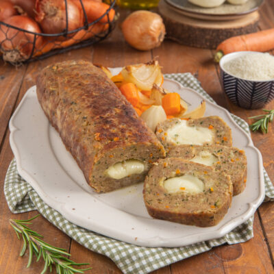 Polpettone con cuore di scamorza affettato, con ripieno filante ben visibile e verdure arrosto