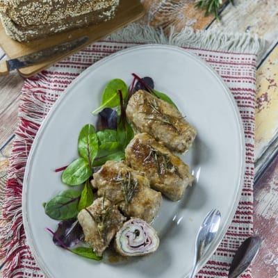 Involtini di manzo con prosciutto e formaggio affettati e serviti con rosmarino e insalatina fresca