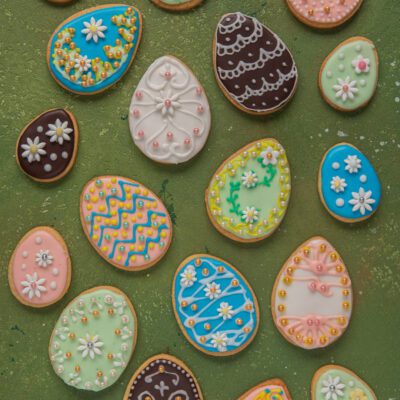 Biscotti di Pasqua a forma di uovo decorati con ghiaccia reale colorata, fiorellini e perline zuccherine