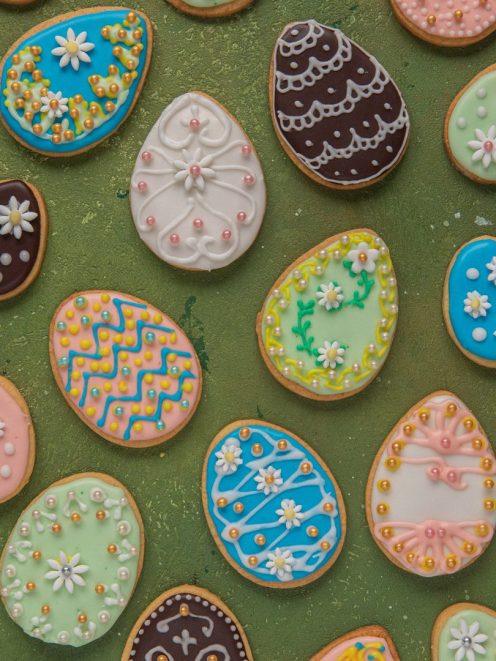 Biscotti di Pasqua a forma di uovo decorati con ghiaccia reale colorata, fiorellini e perline zuccherine