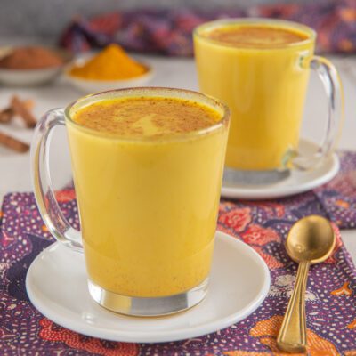 Golden milk con curcuma e cannella in polvere spolverata in superficie