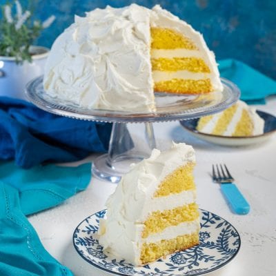 Torta nuvola a strati con pan di Spagna soffice e crema bianca, una fetta in primo piano