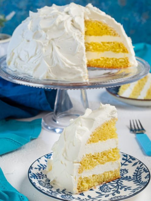 Torta nuvola a strati con pan di Spagna soffice e crema bianca, una fetta in primo piano