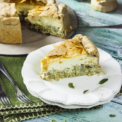 Torta pasqualina con carciofi tagliata a fetta, con ripieno a strati di ricotta e verdure