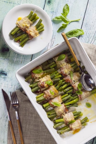 Involtini di pancetta e fagiolini gratinati con parmigiano e foglie di basilico fresco