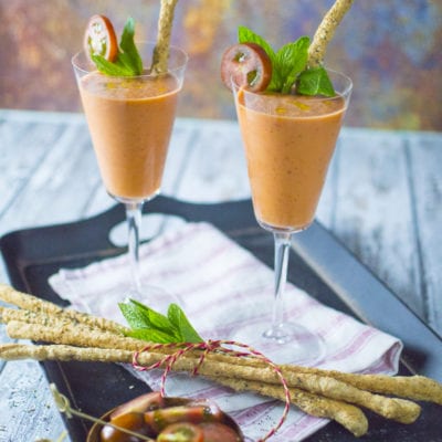 Gazpacho con fragole servito in calici con grissini ai semi, foglie di menta e pomodorini