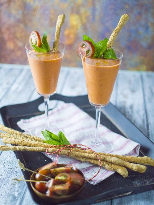 Gazpacho con fragole servito in calici con grissini ai semi, foglie di menta e pomodorini