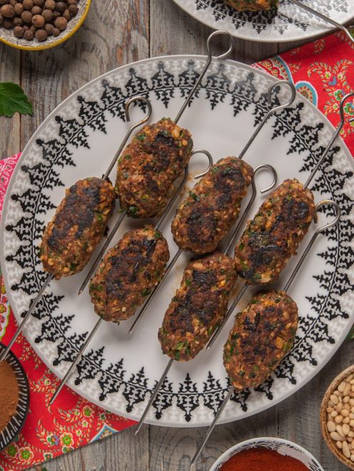 Kofta di carne macinata con erbe aromatiche e pinoli, grigliate su spiedini metallici