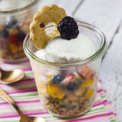 Macedonia con gelato alla vaniglia, frutta mista, granola e mora fresca su biscotto