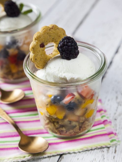 Macedonia con gelato alla vaniglia, frutta mista, granola e mora fresca su biscotto