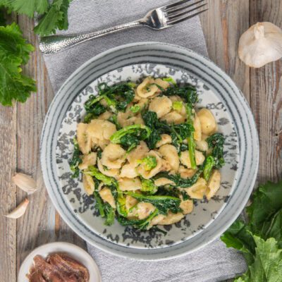 Orecchiette alle cime di rapa condite con aglio e acciughe, servite con foglie saltate in padella