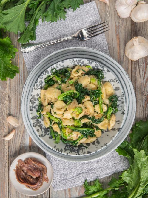 Orecchiette alle cime di rapa condite con aglio e acciughe, servite con foglie saltate in padella
