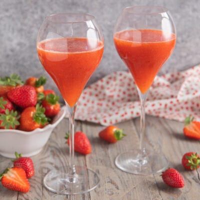 Rossini cocktail servito in due calici con fragole fresche intorno