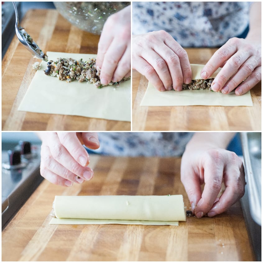 Mani che arrotolano una sfoglia fresca farcita con composto di salsiccia e funghi per formare i cannelloni