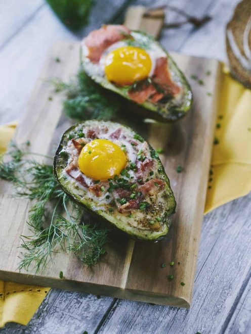 Avocado al forno ripieno con uovo, speck e erba cipollina tritata