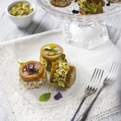 Deliziosa con mousse salate ricoperta di pistacchi tritati e guarnita con fiori eduli