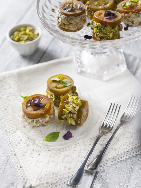 Deliziosa con mousse salate ricoperta di pistacchi tritati e guarnita con fiori eduli