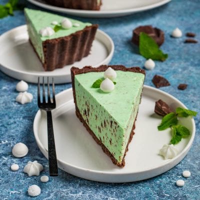 Cheesecake cioccomenta con base al cacao, crema alla menta e scaglie di cioccolato, guarnita con meringhette e foglie di menta
