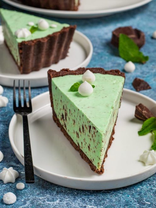 Cheesecake cioccomenta con base al cacao, crema alla menta e scaglie di cioccolato, guarnita con meringhette e foglie di menta