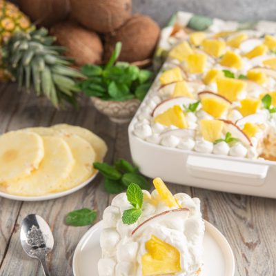 Tiramisù all'ananas e cocco con panna montata, pezzi di ananas e foglioline di menta