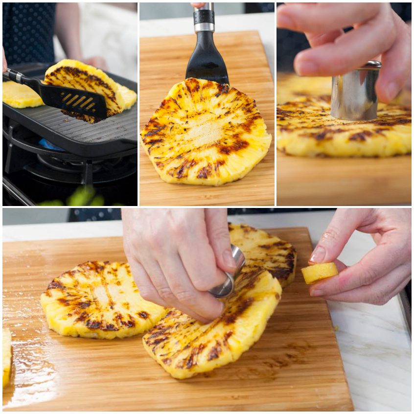 Fette di ananas grigliate con segni di cauterizzazione, poi private del torsolo sul tagliere
