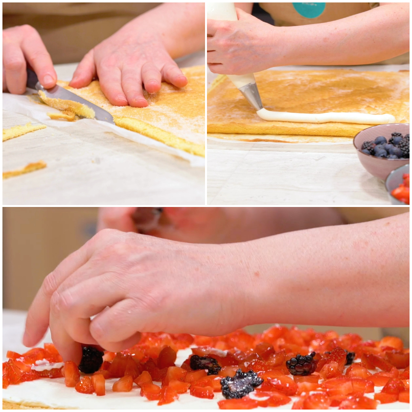 Mani che distribuiscono fragole a pezzetti e frutti di bosco sulla panna stesa sul rotolo