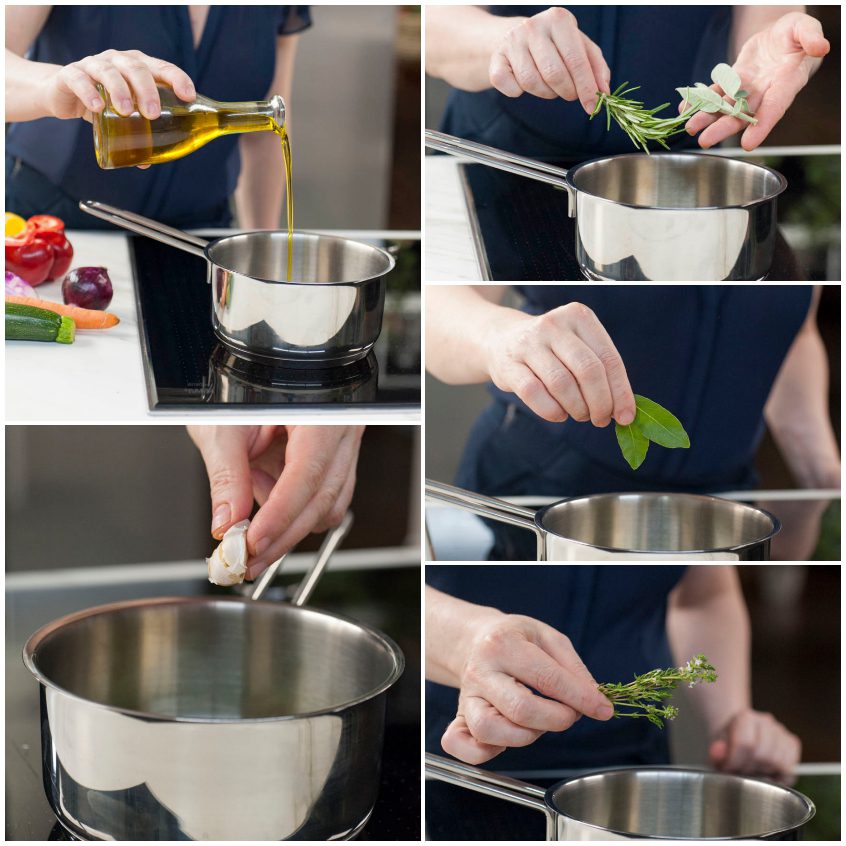 Olio versato in un pentolino con aglio, rosmarino, salvia, alloro e timo freschi