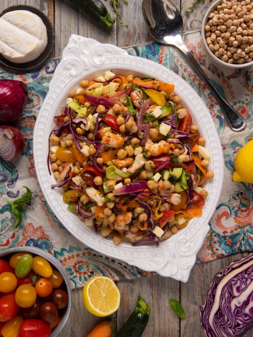 Insalata di ceci con gamberi, verdure a julienne, cavolo rosso e pomodorini condita con erbe fresche