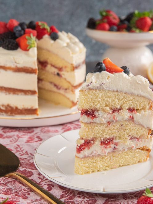 Naked cake senza glutine a strati con panna, frutti di bosco e fragole in cima