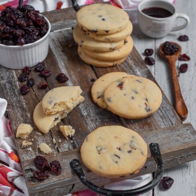 Biscotti ai frutti rossi impilati e spezzati, con cranberry essiccati ben visibili nell'impasto