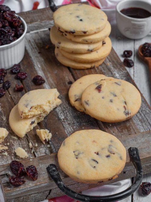 Biscotti ai frutti rossi impilati e spezzati, con cranberry essiccati ben visibili nell'impasto