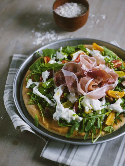 Focaccia senza glutine con rucola fresca, stracciatella, prosciutto crudo e verdure colorate