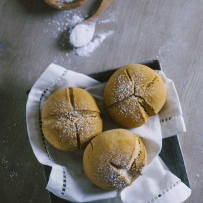 Tre panini di soda bread senza glutine con incisione a croce e spolverata di farina