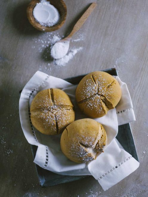 Tre panini di soda bread senza glutine con incisione a croce e spolverata di farina