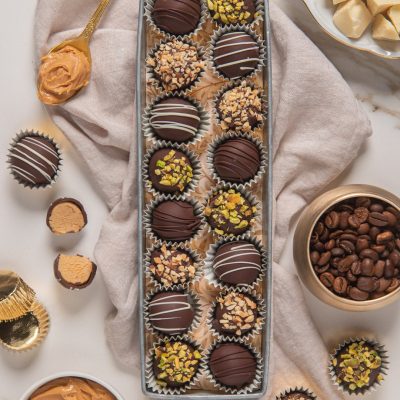 Praline al cioccolato fondente con granella di pistacchi, nocciole e glassa bianca in vassoio
