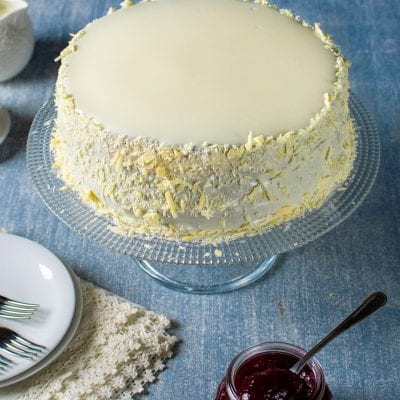 Sacher senza glutine al cioccolato bianco con glassa liscia e scaglie sui lati