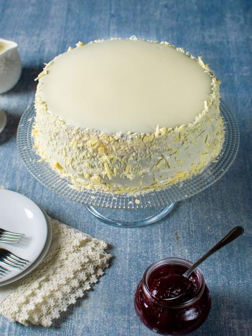 Sacher senza glutine al cioccolato bianco con glassa liscia e scaglie sui lati