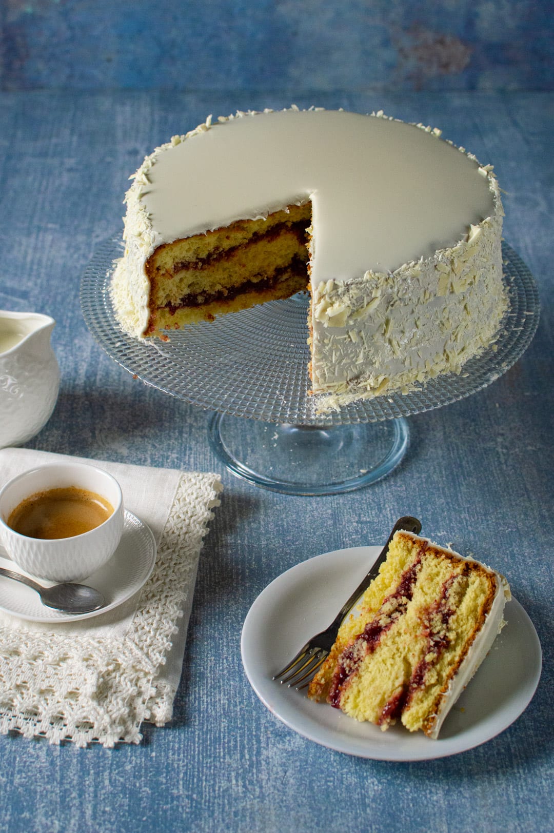 Fetta di Sacher senza glutine con strati di marmellata e copertura al cioccolato bianco