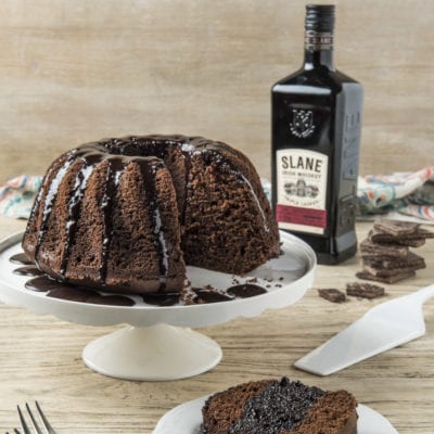 Bundt cake al cioccolato con glassa fondente colante, una fetta servita in primo piano