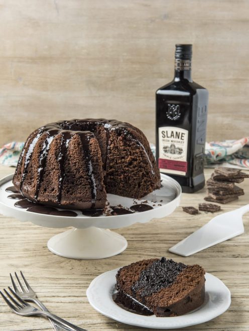 Bundt cake al cioccolato con glassa fondente colante, una fetta servita in primo piano