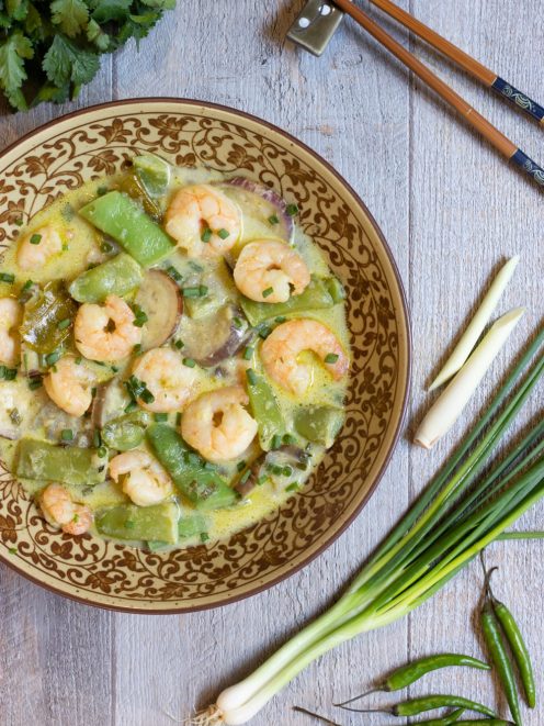 Curry verde con gamberi, taccole e melanzane in salsa cremosa, guarnito con erba cipollina