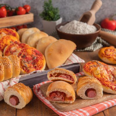 Rosticceria siciliana con pizzette, calzoncini e rotoli con wurstel e sesamo