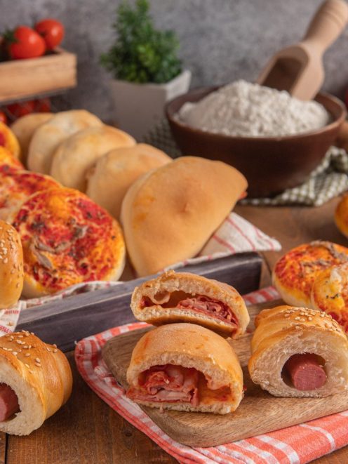 Rosticceria siciliana con pizzette, calzoncini e rotoli con wurstel e sesamo