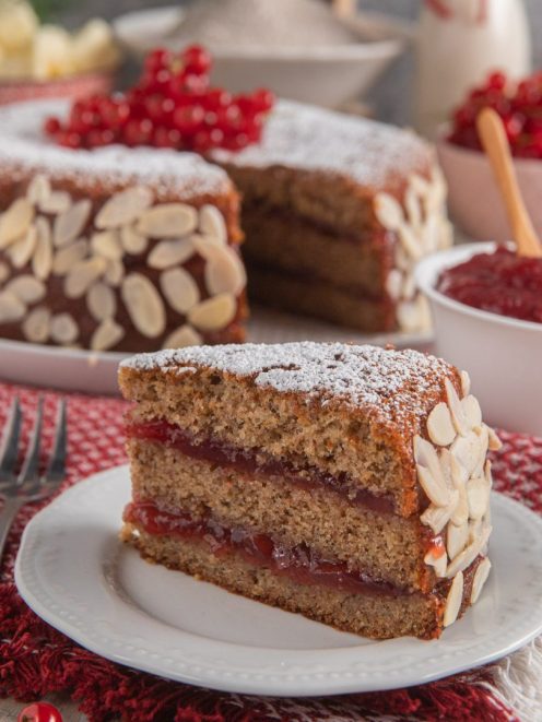 Torta di grano saraceno e ribes con strati di confettura, mandorle a lamelle sui bordi e zucchero a velo