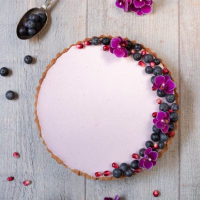 Crostata primavera senza glutine con crema rosa, mirtilli, melograno e fiori eduli