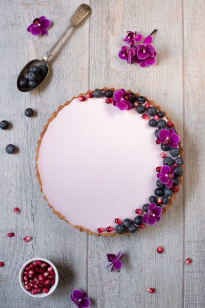 Crostata primavera senza glutine con crema rosa, mirtilli, melograno e fiori eduli