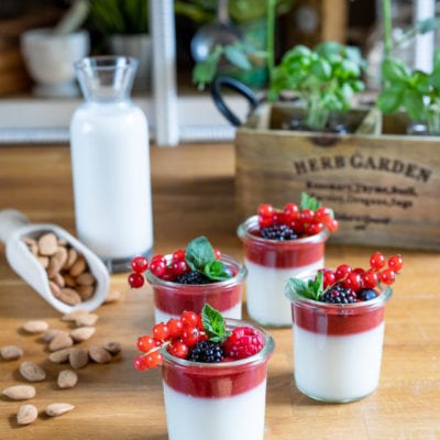 Finta panna cotta al latte di mandorla in bicchierini con coulis di frutti rossi e ribes fresco